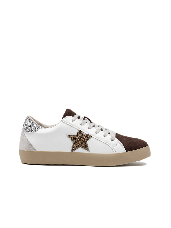 Zapatillas blancas con estrella de purpurina dorada y puntera café.