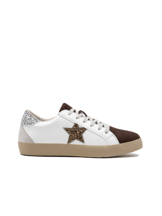 Zapatillas blancas con estrella de purpurina dorada y puntera café.