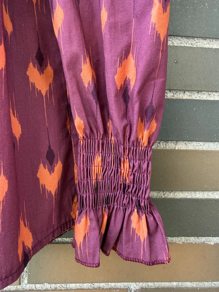 Conjunto vintage de blusa fruncida y falda larga con estampado ikat en tonos morados y naranjas