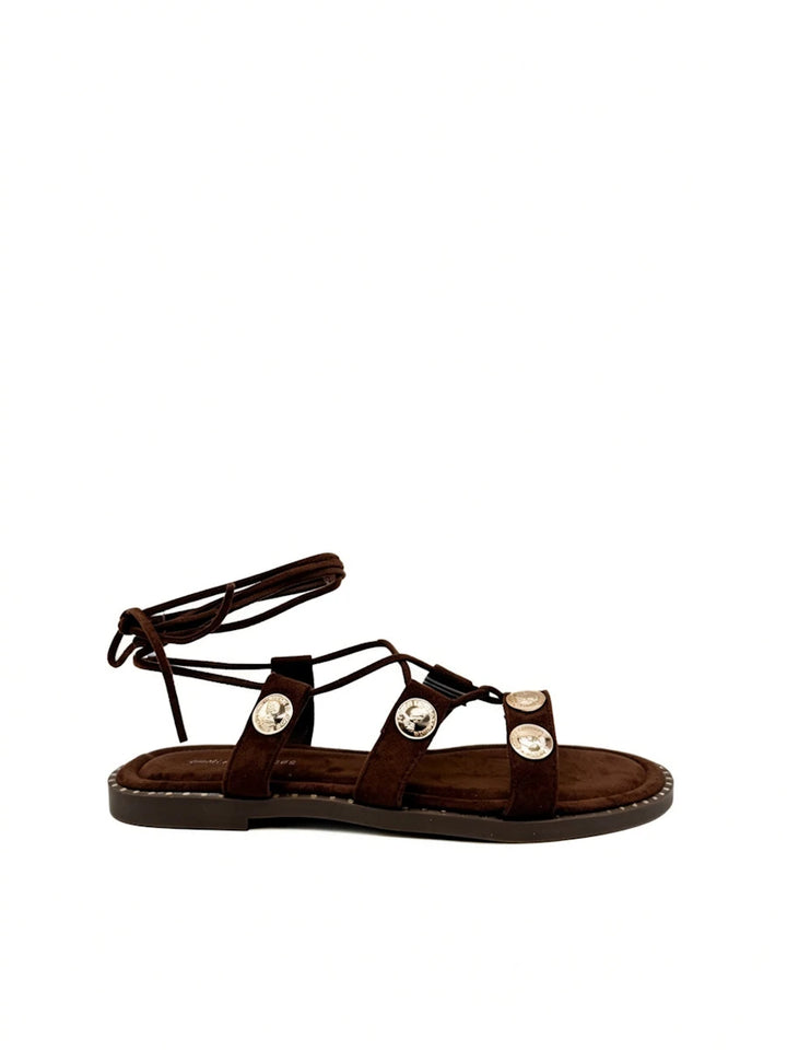 Sandalias romanas marrón oscuro con monedas doradas.