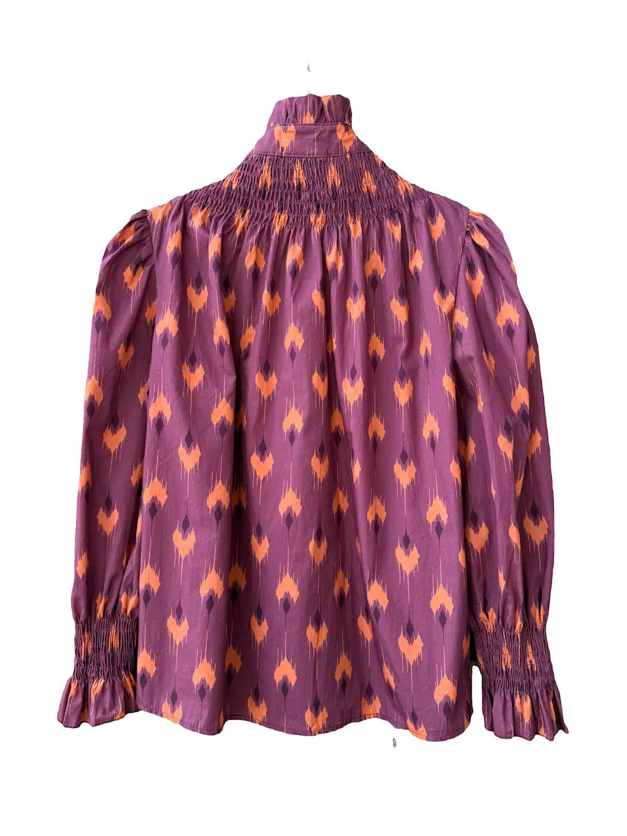 Conjunto vintage de blusa fruncida y falda larga con estampado ikat en tonos morados y naranjas