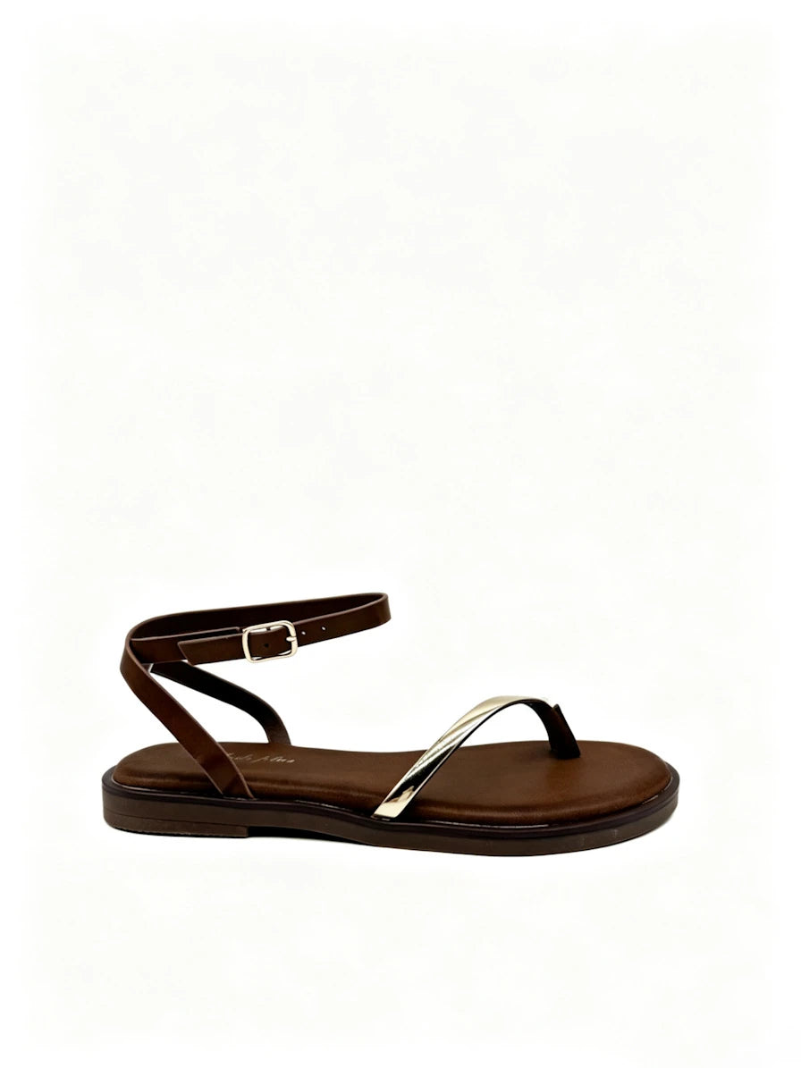 Sandalias planas marrones con tira flexible dorada.