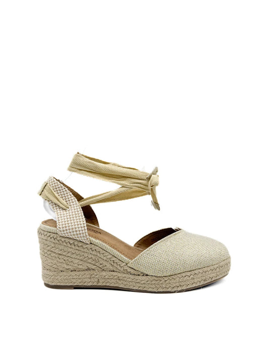 Alpargatas de cuña beige con cintas y acabado brillante.