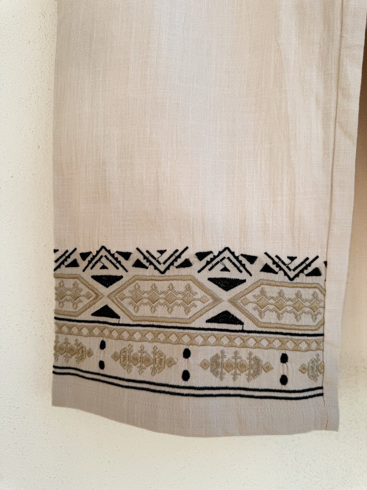 Pantalón de corte recto con bordados geométricos en negro y dorado