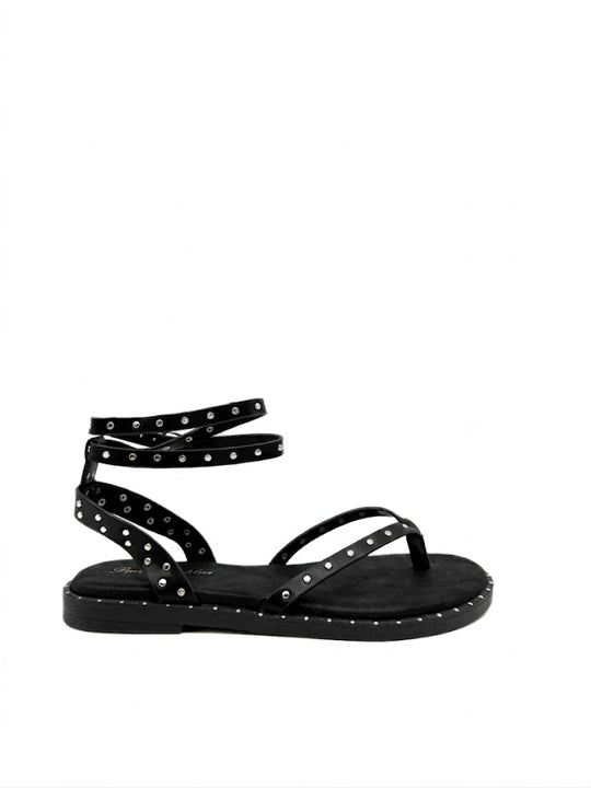 Sandalias planas de dedo con tachas metálicas para mujer.